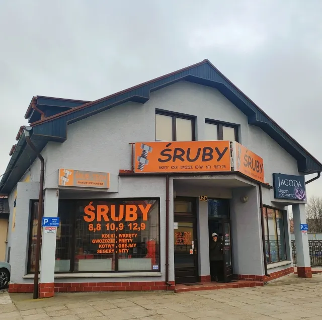 Budynek sklepu Śrub-Tech przy ul. Lipowej 12A w Oławie z pomarańczowymi szyldami „Śruby”